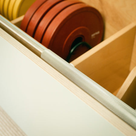 Close-up of a soft grey Fittle Box with a barbell and weight plates inside 