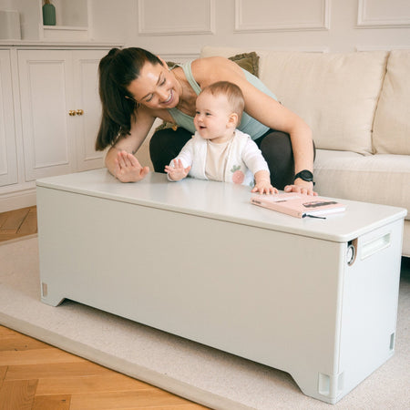 Mother and baby using Fittle home gym storage bench as living room coffee table
