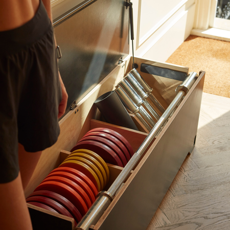 Fittle Box all-in-one home gym bench with integrated storage, barbell, colour-coded weight plates and mat neatly organised inside premium strength training system