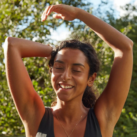 Woman stretching outdoors after a home workout, reflecting Fittle’s approach to accessible, strength-focused home fitness.
