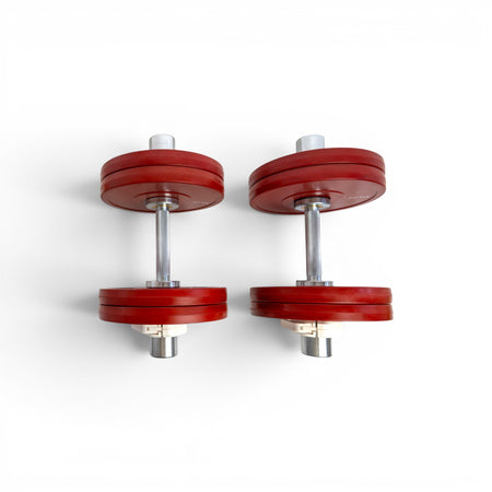 Pair of Fittle adjustable dumbbells with red weight plates on a white background 